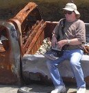 Bob decides to check his directions after coming across a shell of a car on the beach